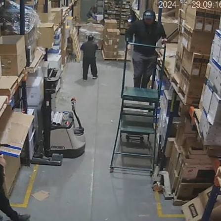 Original, unannotated warehouse aisle photo with a forklift, boxes, and workers